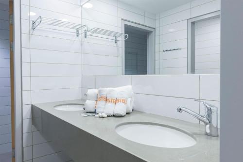 ein Badezimmer mit zwei Waschbecken und zwei Spiegeln in der Unterkunft HI - Haifa Hostel in Haifa