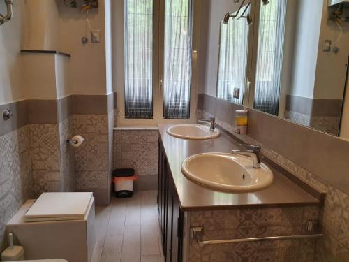 een badkamer met 2 wastafels en een toilet bij B&B Enjoy Ercolano in Ercolano