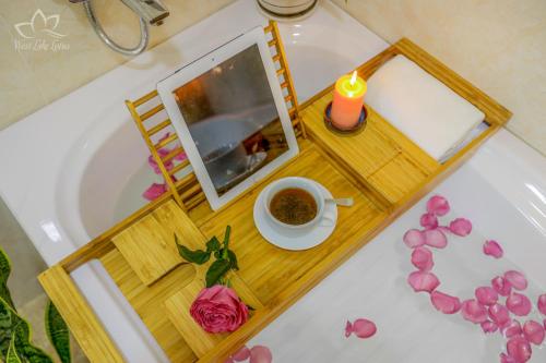 a tray with a cup of coffee and a picture on a bath tub at The Lakeview - West Lake Lotus Apartments in Hanoi