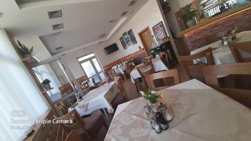 a dining room with a table and chairs with flowers on it at Prenoćište i restoran Ihthis in Bajina Bašta