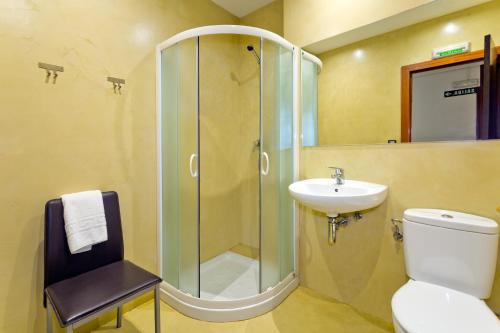 y baño con ducha, aseo y lavamanos. en Pension Casa Otano, en Pamplona