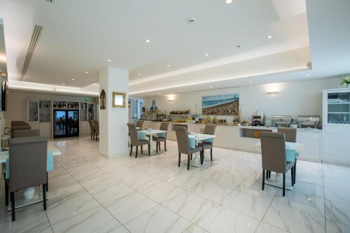 a restaurant with tables and chairs and a kitchen at Rimini Suite Hotel in Rimini