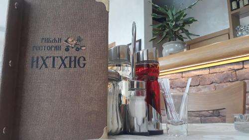a book sitting on top of a table with glasses at Prenoćište i restoran Ihthis in Bajina Bašta