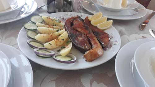 a plate of food with meat and vegetables on a table at Prenoćište i restoran Ihthis in Bajina Bašta