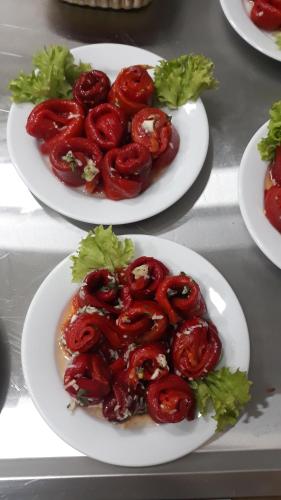 three plates of food with tomatoes and lettuce on a table at Prenoćište i restoran Ihthis in Bajina Bašta