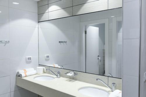 a bathroom with two sinks and a large mirror at HI - Karei Deshe Hostel in Khirbet Minim