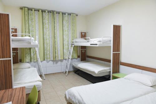 um dormitório com 2 beliches e uma secretária em HI - Karei Deshe Hostel em Khirbet Minim