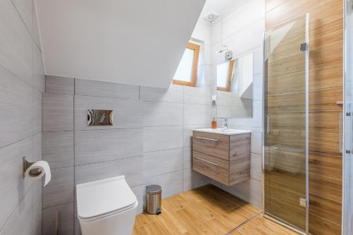 a bathroom with a toilet and a shower at Apartamenty na Spacerowej in Dębki