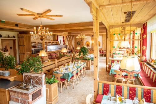 a dining room with tables and chairs and a chandelier at Familien-Appartements Örglwirt's Gut in Mariapfarr