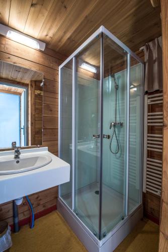 une salle de bain avec une douche en verre et un lavabo dans l'établissement Les Chalets by Le Marintan, à Saint-Michel-de-Maurienne