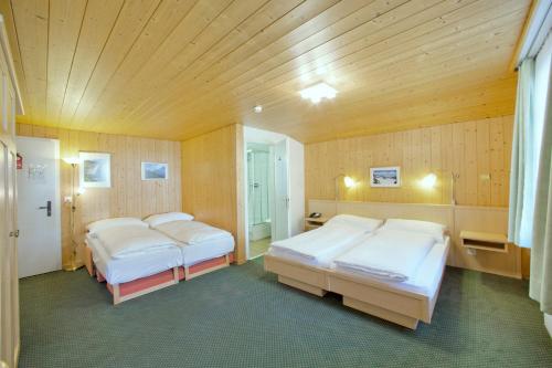 A bed or beds in a room at Hotel Alpenruh