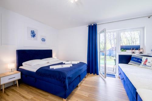 a bedroom with two beds and a window at Apartament 1B Blue Marine Poddąbie in Poddąbie