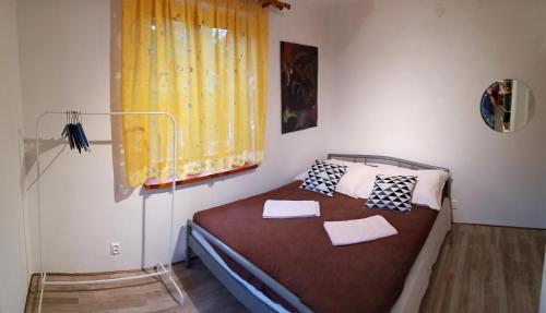 a bedroom with a bed with a yellow curtain and a window at Apartmán U Zebry in Bílá Třemešná