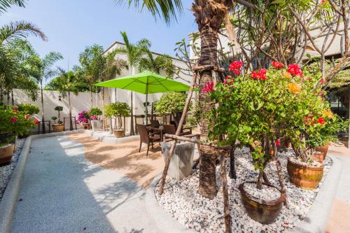 um pátio com um guarda-chuva verde e algumas plantas em Top Pool Villa B5 em Pattaya Central