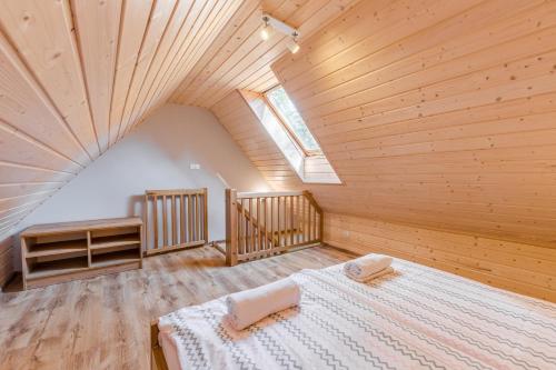 a bedroom with a large bed in a wooden ceiling at Apartamenty na Spacerowej in Dębki