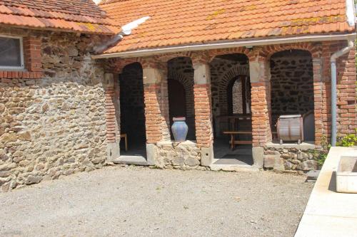 an old brick building with an open entry way at Domaine de La Couture in Évaux-les-Bains