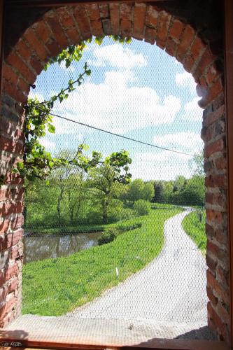a brick window with a view of a walkway at Domaine de La Couture in Évaux-les-Bains