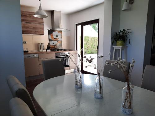 a kitchen with a table with flowers in vases on it at Spacious Apartment "Ana" on lake Sabljaci in Ogulin