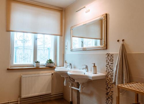 a bathroom with two sinks and a mirror at Guest house in Dobele city center- Pilsētas Māja in Dobele