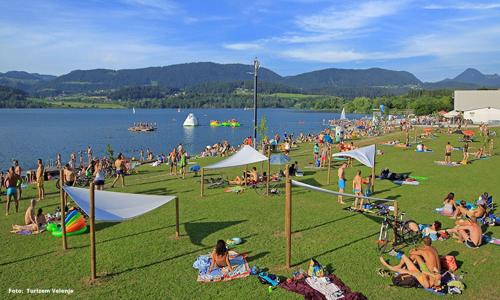 a large group of people sitting on the grass at a beach at Hotel Razgorsek in Velenje