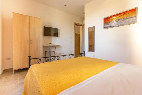 ein Schlafzimmer mit einem Bett mit einer gelben Decke in der Unterkunft Casina Sofia by BarbarHouse in Leverano