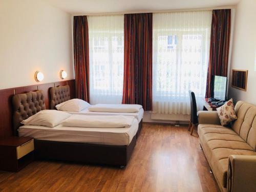 ミュンヘンにあるホテル ヴェルディのベッドルーム(ベッド1台、ソファ付)