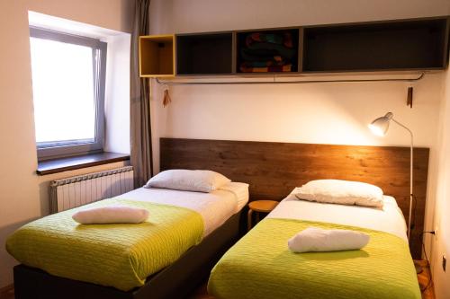 two beds in a room with yellow and white at Hostel Museum in Koper