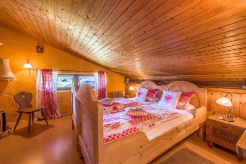 ein Schlafzimmer mit einem Bett in einer Holzhütte in der Unterkunft Direkt zwischen Chiemsee u Alpen Dg in Bernau am Chiemsee