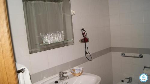 a bathroom with a sink and a mirror and a tub at Colina do Mar in Albufeira
