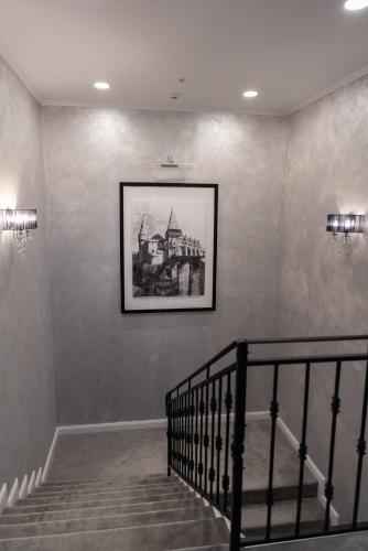 a staircase with a picture of a building on a wall at Krystal Boutique Mansion in Hunedoara