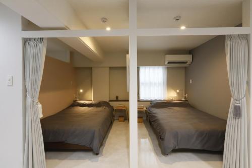 Ένα ή περισσότερα κρεβάτια σε δωμάτιο στο コンドミニアムHARU 那覇県庁前 201
