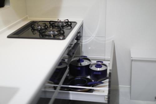 a kitchen with a stove with pots and pans at コンドミニアムHARU 那覇県庁前 201 in Naha