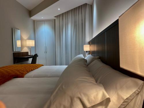 een hotelkamer met twee bedden en een muur bij Harpazul in Catoira
