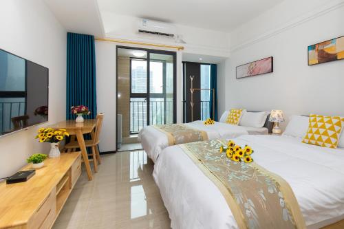 a hotel room with two beds and a television at Foshan Laide Apartment in Shunde