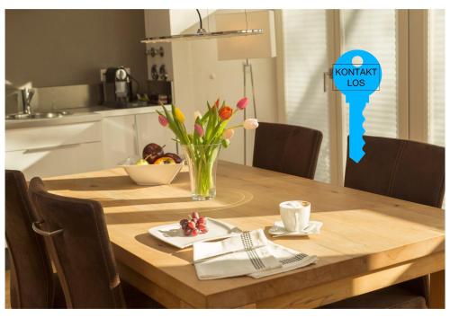 a wooden table with a vase of flowers on it at Paleo Finest Serviced Apartments in Munich