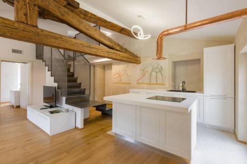 eine Küche mit weißen Schränken und einer Treppe in der Unterkunft Luxury Design Apt with Amazing View in Verona