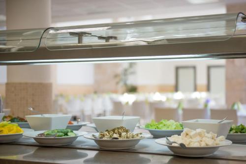 a buffet line with bowls of food on a counter at HI - Akko Knights Hostel in ‘Akko