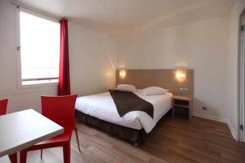 1 dormitorio con cama, mesa y ventana en Geneva Residence en Gaillard