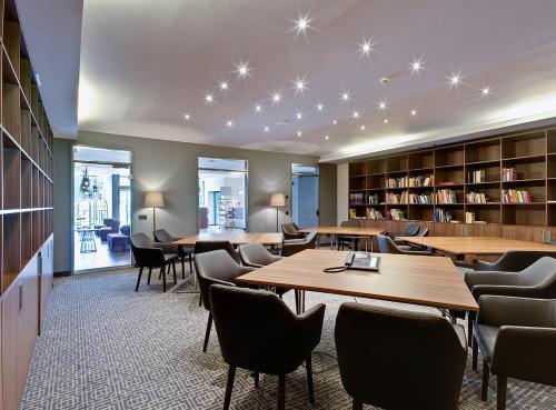 a library with tables and chairs and bookshelves at Sante Royale Hotel- & Gesundheitsresort Bad Langensalza in Bad Langensalza