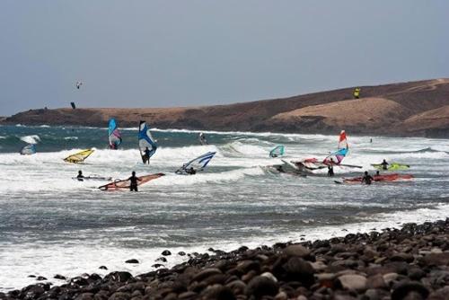 a group of people in the ocean with surfboards at Wild House in Las Palmas de Gran Canaria