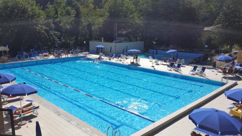 uma grande piscina com cadeiras e guarda-sóis em Hotel La Pace em Maresca