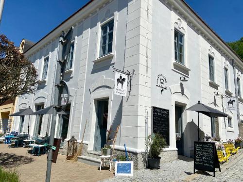 a white building with umbrellas in front of it at Penzion Masarykova 37 Hluboká nad Vltavou in Hluboká nad Vltavou