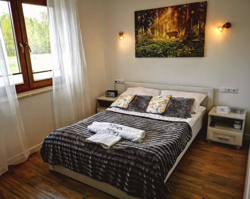 1 dormitorio con 1 cama con una pintura en la pared en Agroturystyka Serce Łysicy, en Święta Katarzyna