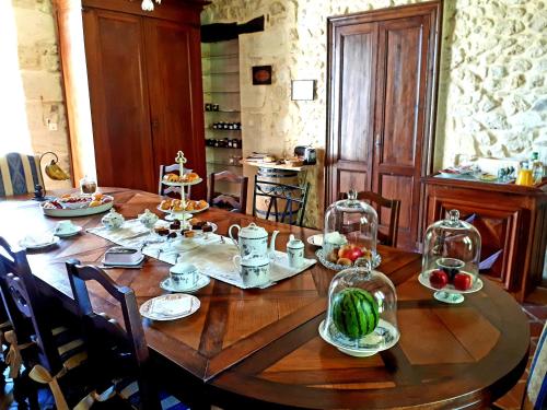 une table en bois avec des assiettes de nourriture dessus dans l'établissement Domaine de Garat, à Floirac
