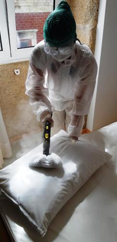a person using asaw to cut a pillow on a bed at Almar Apartments in Póvoa de Varzim