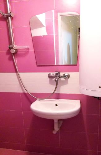 a pink bathroom with a sink and a mirror at APARTMENT LEO 2 in Varna City
