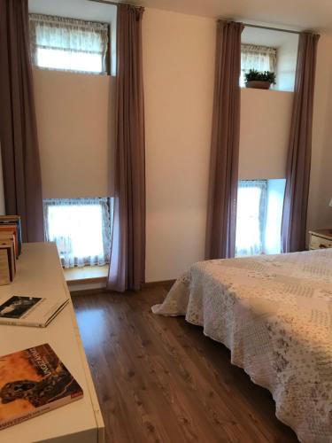 een slaapkamer met een bed en 2 ramen bij Pferdehof Dietzsch, Tittmoning in Tittmoning
