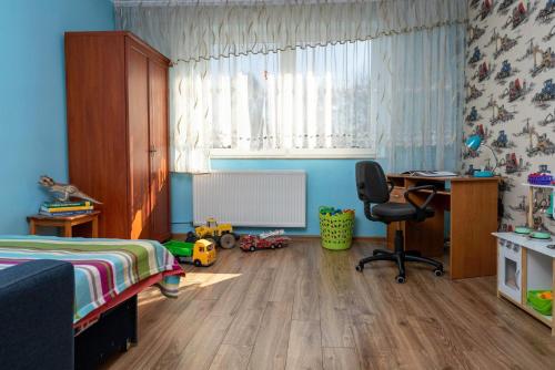 a bedroom with a bed and a desk and a chair at Agroturystyka Gawryś pokoje in Sasino