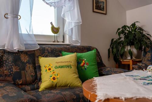 a couch with two green pillows on it at Agroturystyka Gawryś pokoje in Sasino