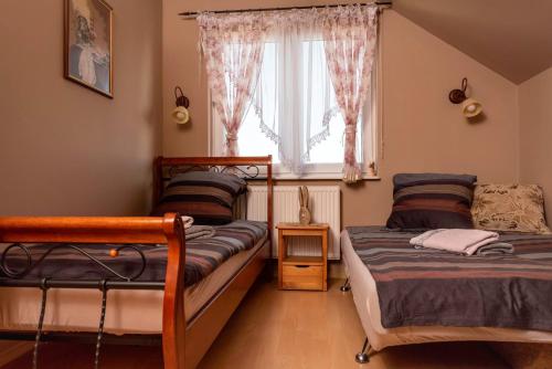 1 dormitorio con 2 camas y ventana en Agroturystyka Gawryś pokoje, en Sasino